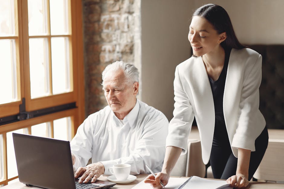 Senior businessman working with a young colleague in a modern office setting